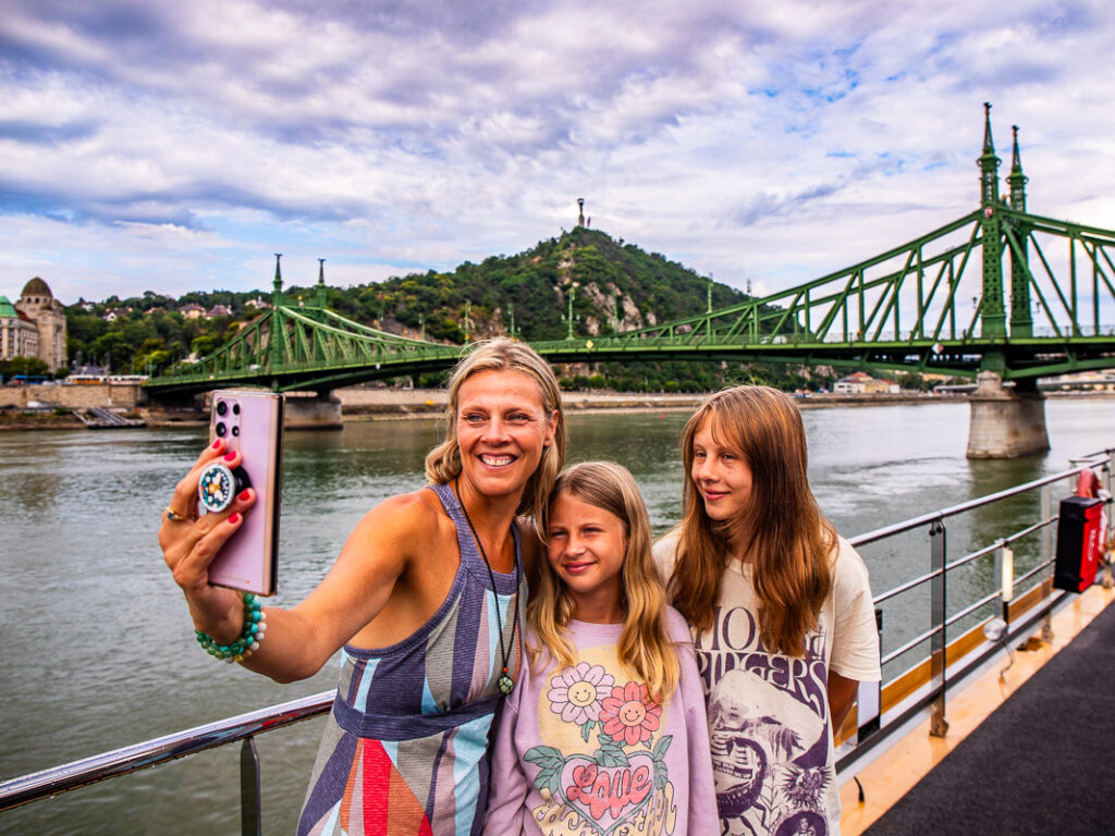 Mom taking a selfie photo with two daughters on a river cruise
