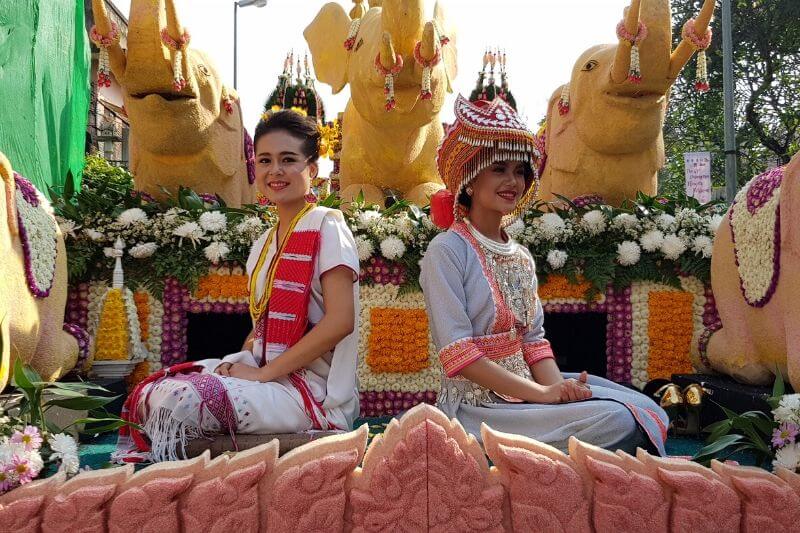 two thai women on a float in traditional dress