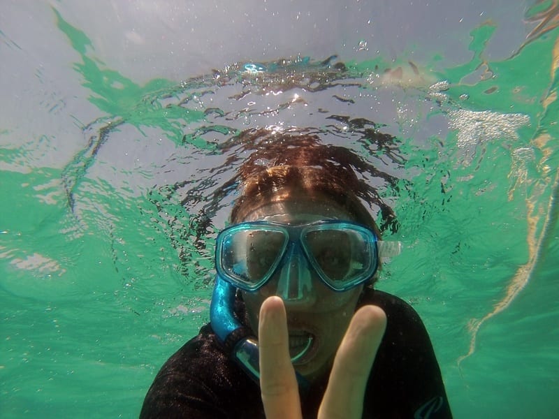 caz giving peace sign to camera underwater