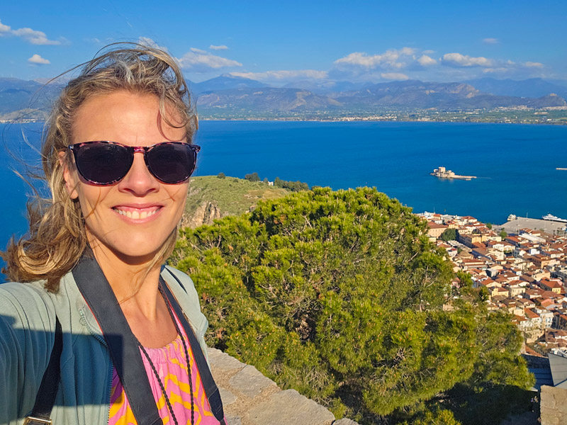 caz smiling at camera with views of nafplio and sea behind her