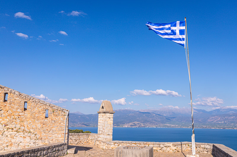 greece flag flying on top of fortress